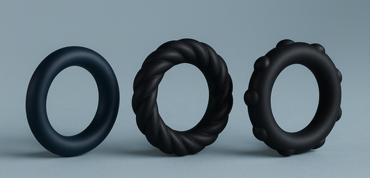 Two soft silicone cock rings in black and blue, placed on a silky surface with modern lighting – ideal for beginner users.