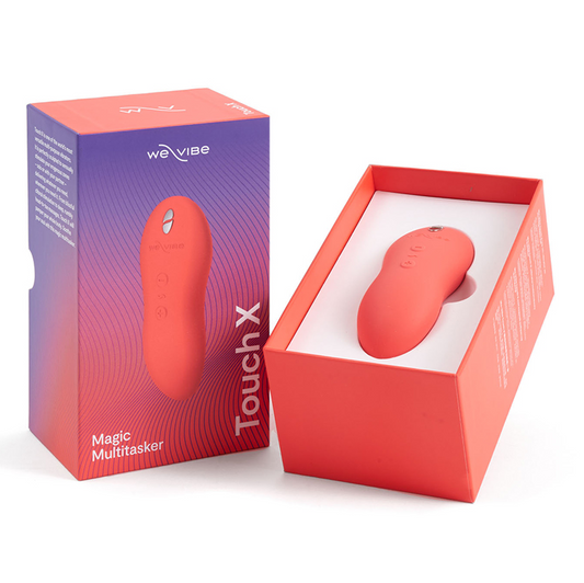 A red and white We Vibe Touch X vibrator next to its open orange box, with the product's name and features visible on the box.