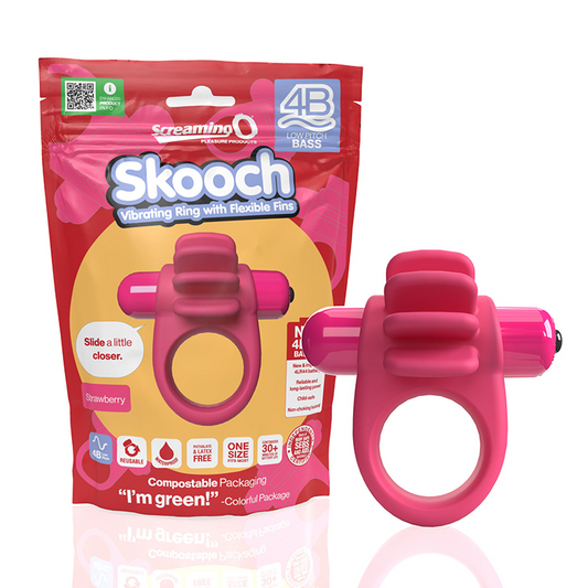 A pink vibrating cock ring with four flexible fins, shown both in and out of its packaging. The packaging highlights its strawberry flavor and features, including a ring with a wide band and a powerful 4B motor for deep rumbling vibrations.