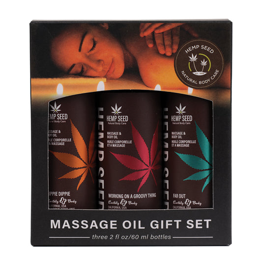 A packaging box containing three bottles of Earthly Body massage oil with different colored labels representing different scents, such as coconut lime, mango, and basil.
