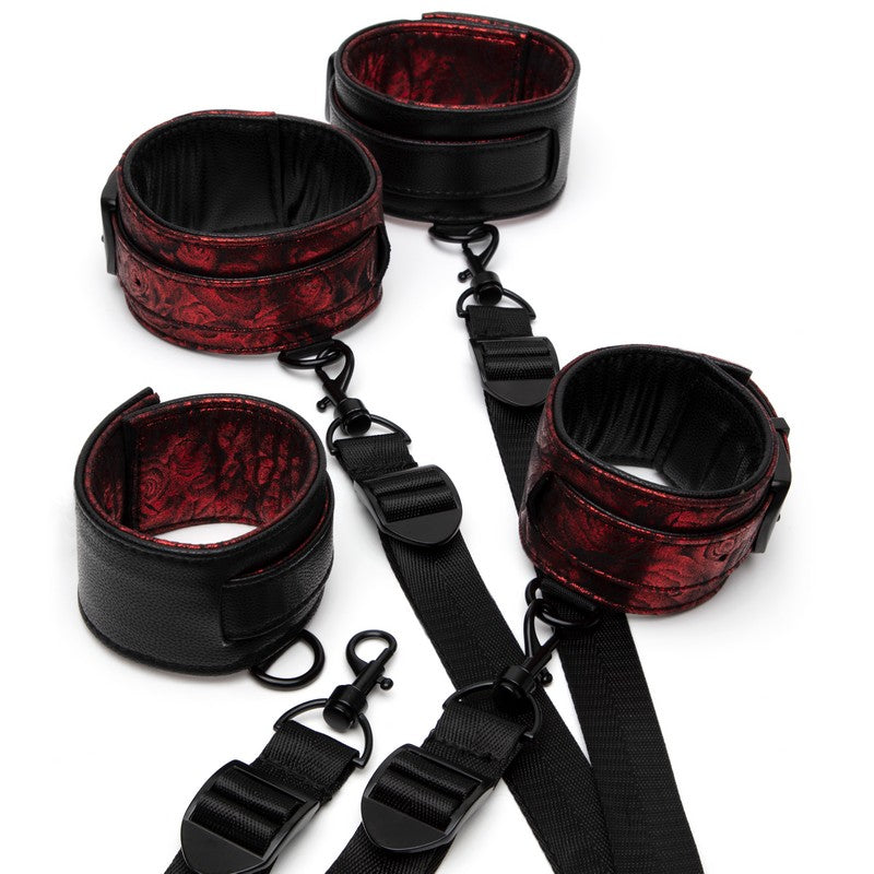 Black and red leather restraint set on a white background