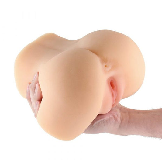 Realistic silicone breast model held by a hand on a white background