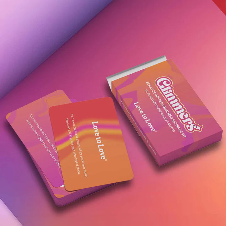 The image shows a box and several cards from the Love to Love Glimmers Personalized Message Kit. The cards are colorful with a mix of orange, pink, and purple hues, and feature text and scratch-off stickers.