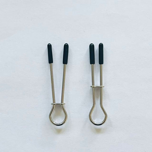Minimalist stainless steel loop nipple clamps with black rubber tips on white background.