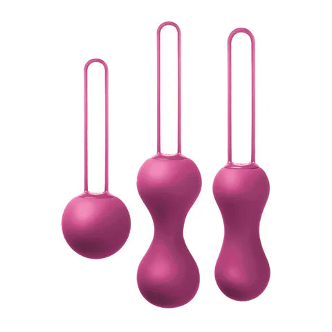 Three pink silicone hanging balls with strings on a white background