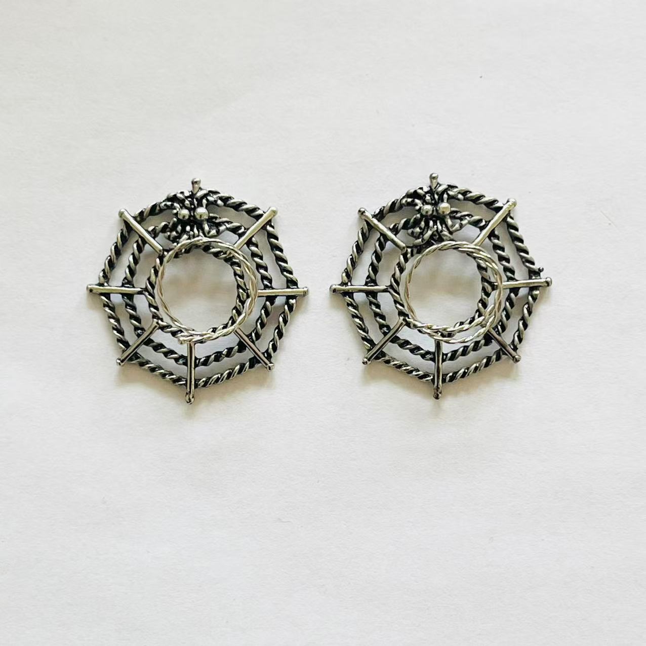 Pair of spider web-shaped metal nipple rings 