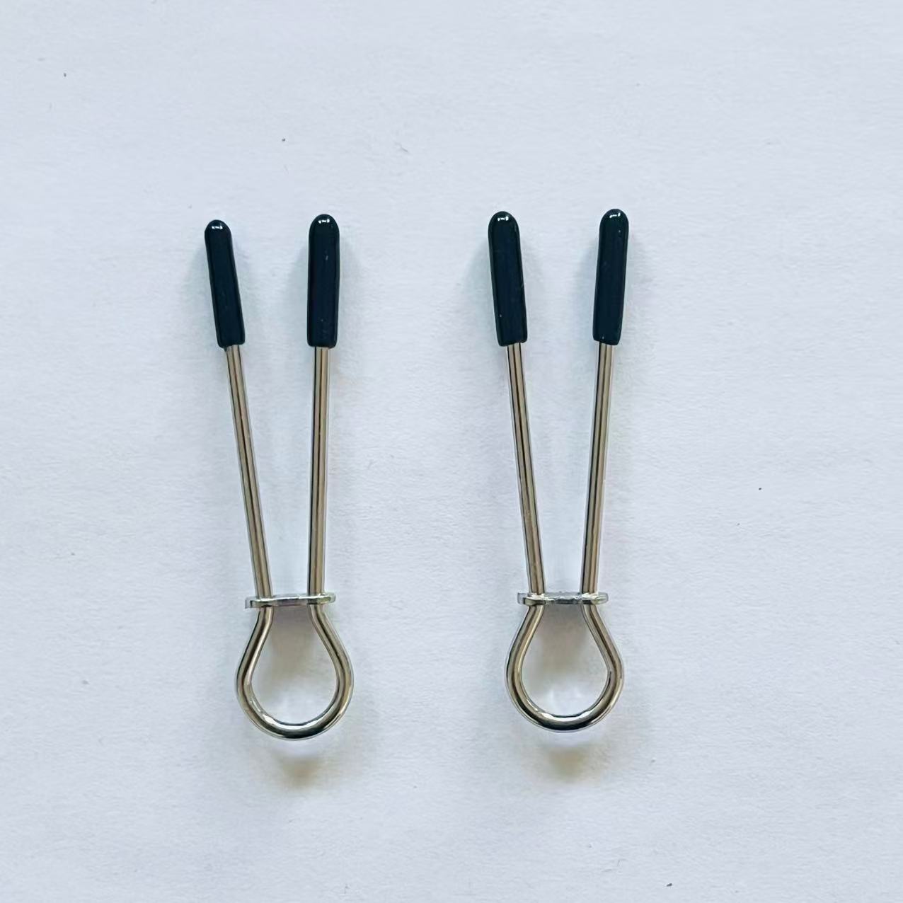 Minimalist stainless steel loop nipple clamps with black rubber tips on white background.