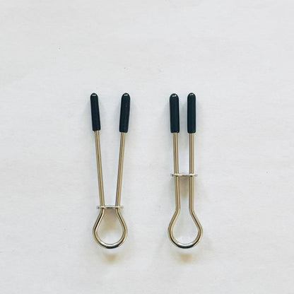 Minimalist stainless steel loop nipple clamps with black rubber tips on white background.