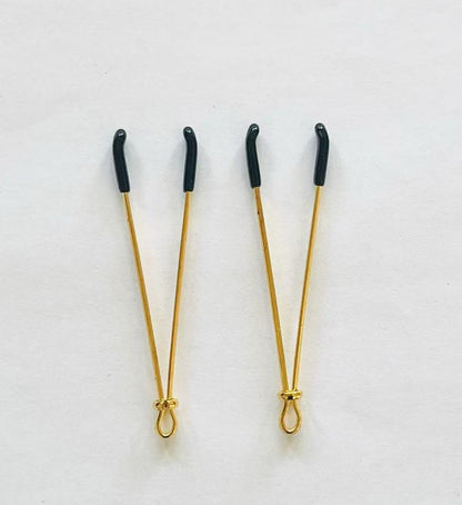 Gold adjustable wire-style nipple clamps with black rubber tips, minimalist BDSM design