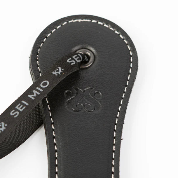 SEI MIO Rule My World Flexible Impact Paddle – black faux leather spanking paddle with wrist loop for BDSM and dominance play.