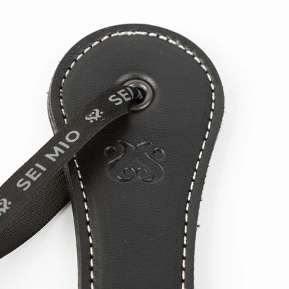 SEI MIO Rule My World Flexible Impact Paddle – black faux leather spanking paddle with wrist loop for BDSM and dominance play.