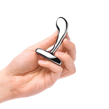 Three stainless steel anal plugs from the b-Vibe P-Spot Training Set in small, medium, and large sizes displayed against a reflective background.