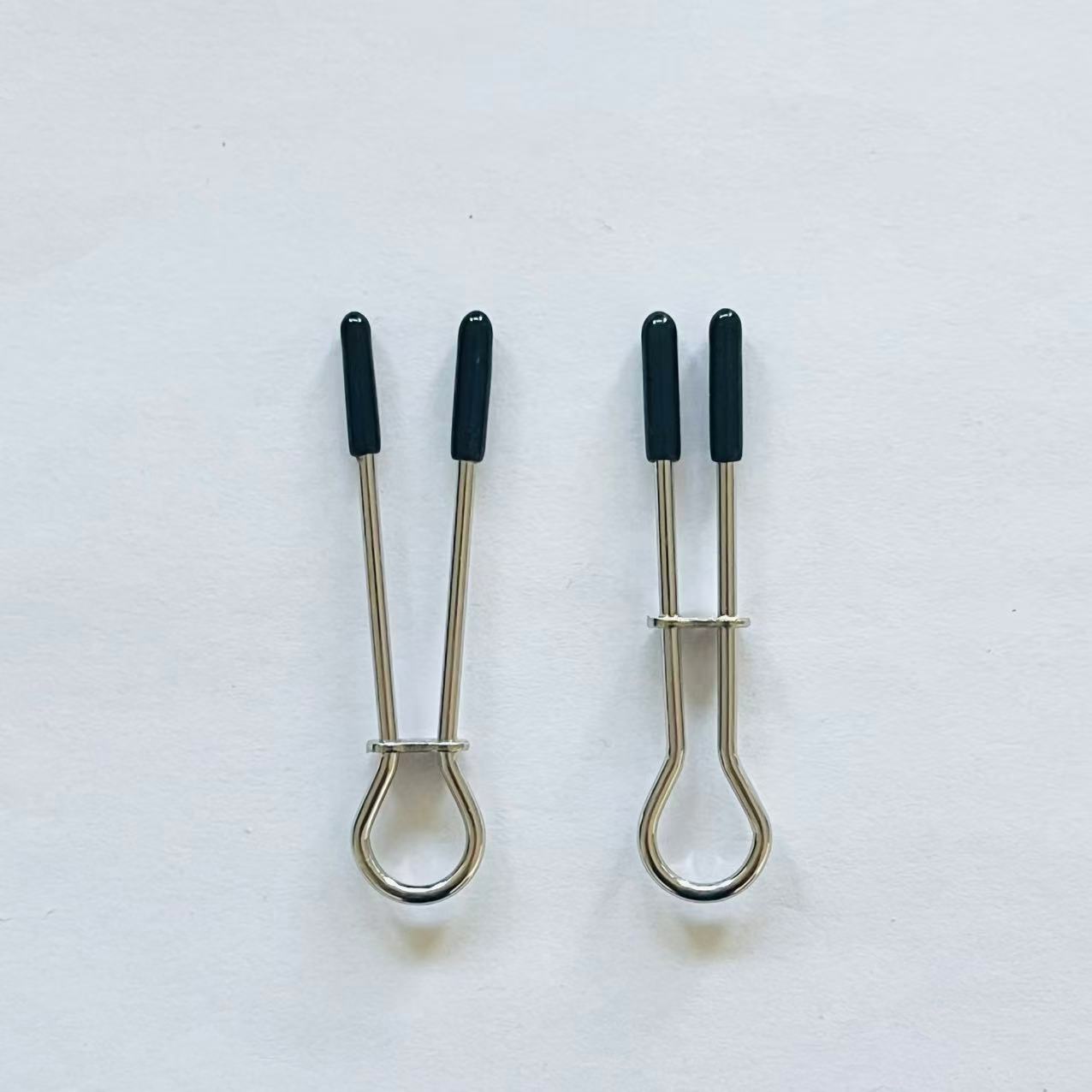 Minimalist stainless steel loop nipple clamps with black rubber tips on white background.