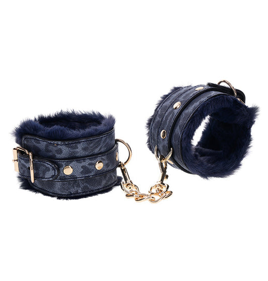 A pair of blue faux fur handcuffs with gold-plated hardware, featuring a chain connection and adjustable buckle.